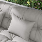 Light grey square throw pillow and padded seat cushions on a patio swing
