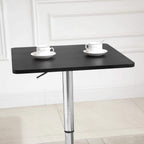 Black square bar table with chrome pedestal base and two cups on the tabletop.