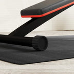 Close-up of black workout mat with textured surface under equipment foot