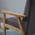Grey upholstered accent chair with light wood armrest and cushioned seat