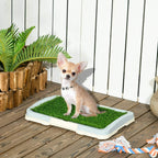 Portable indoor puppy training pad with green artificial grass, used by a small dog