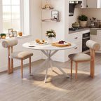 White round dining table with steel legs and beige upholstered bench-style chairs