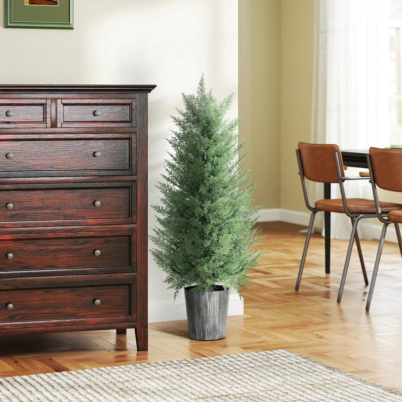 Artificial cypress tree with green foliage in gray textured pot, standing indoors