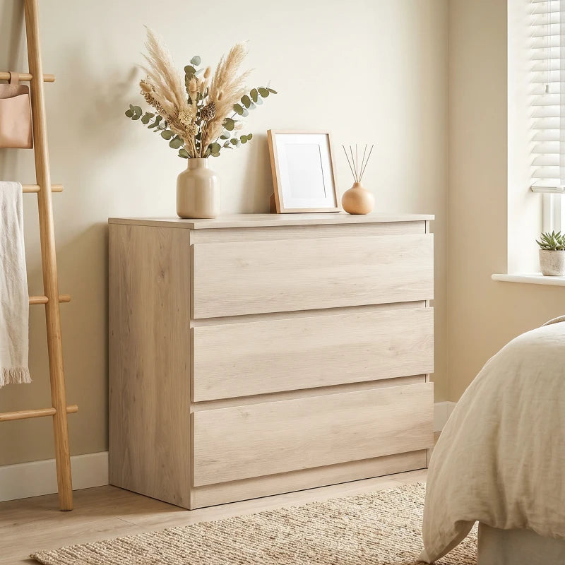 Oak 3-drawer chest with front view and top surface styled with vase and frame.
