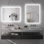 Pair of LED bathroom vanity mirrors with illuminated borders on a stone wall