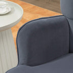Dark grey wingback accent chair arm and curved backrest, button-tufted upholstery