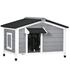 Grey wooden dog kennel with black sloped roof, front opening, and elevated legs
