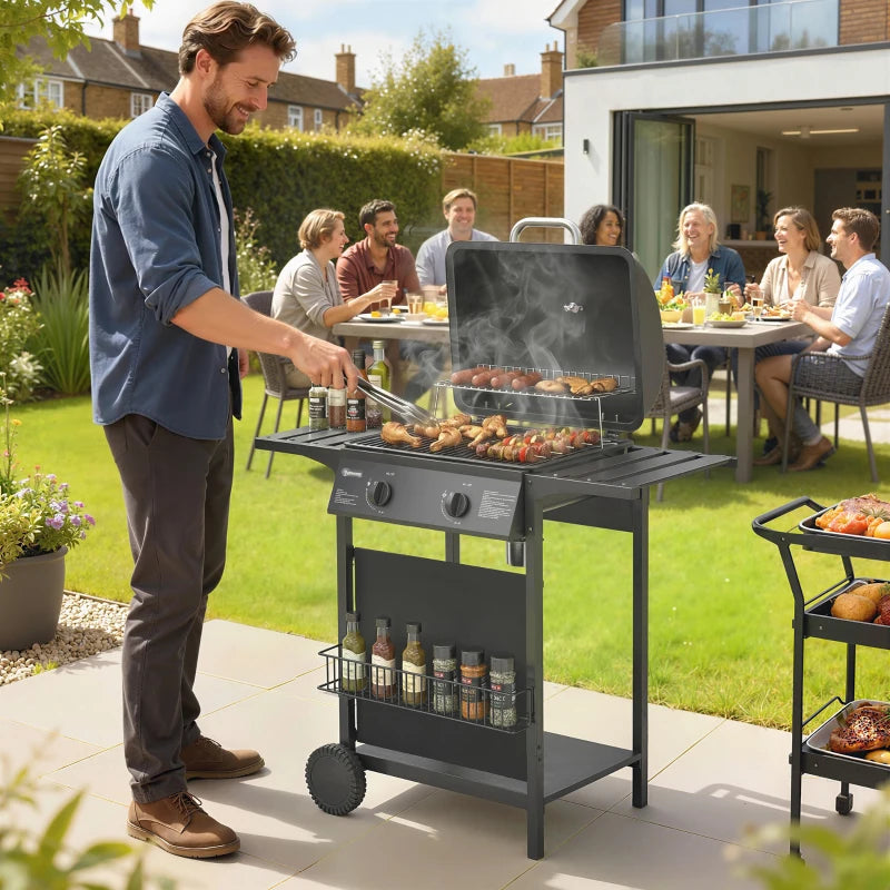 Black 2-burner gas barbecue grill in use with lid open and food on the grate