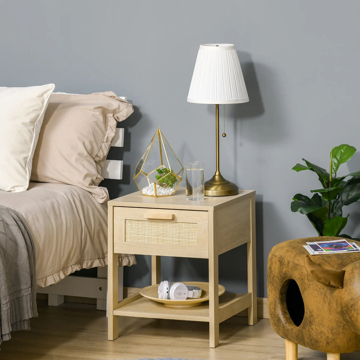 Natural wood bedside table with rattan drawer and lower shelf beside a bed
