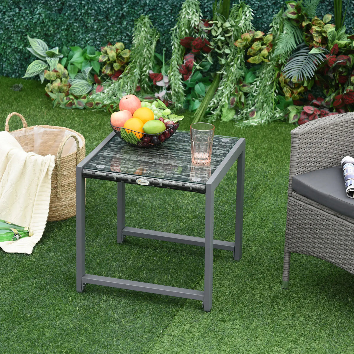 Grey rattan end table beside patio seating, with glass top