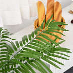 Artificial palm fronds with green leaves and stems, close-up view